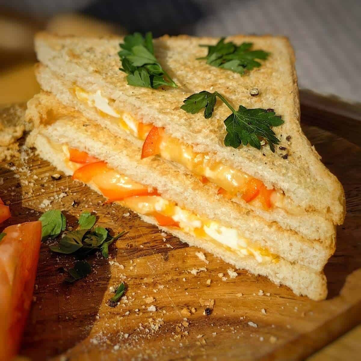 This looks like a delicious fried egg sandwich with tomato and cheese. The bread is toasted to a golden brown, and the egg is cooked perfectly sunny-side up.