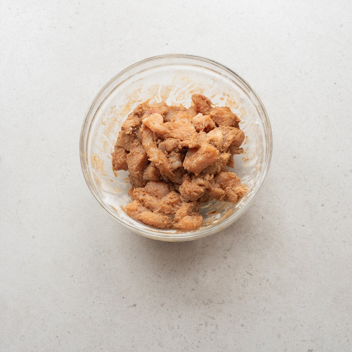 chicken with soy sauce, cornstarch and flour in a bowl