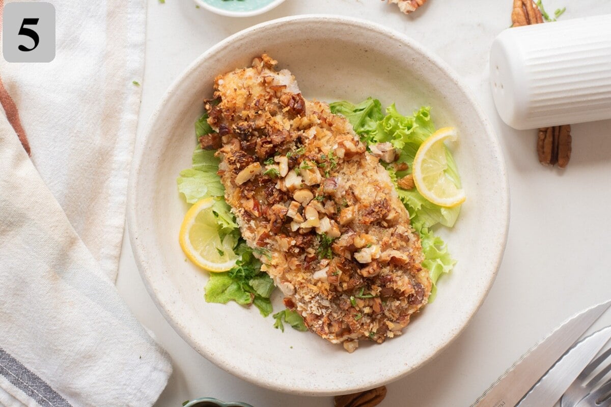 slicing and serving air fryer pecan crusted chicken.