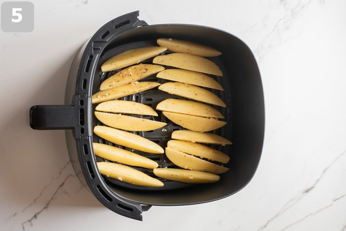 Arrange the potato wedges in a single layer in the air fryer basket.