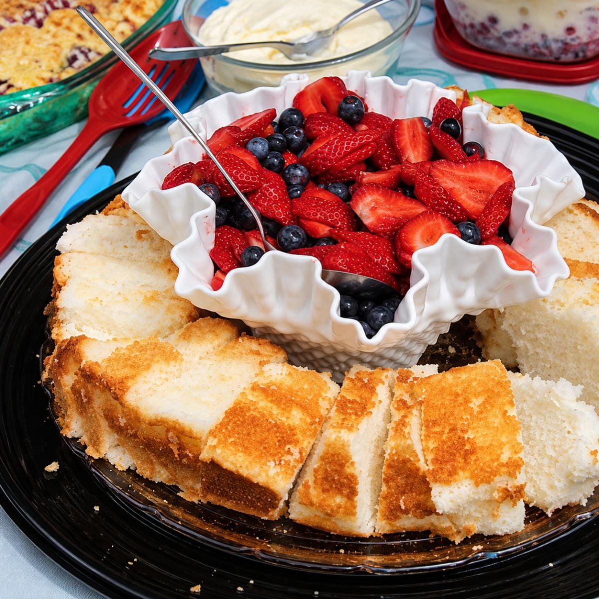 Angel Food Cake in a circular dish with fresh fruit on top