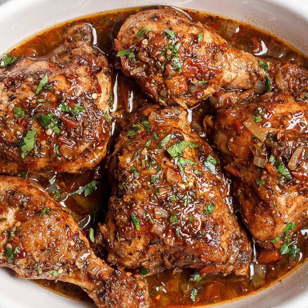Honey balsamic chicken pieces cooked in a rich, savory sauce with onions and fresh herbs[