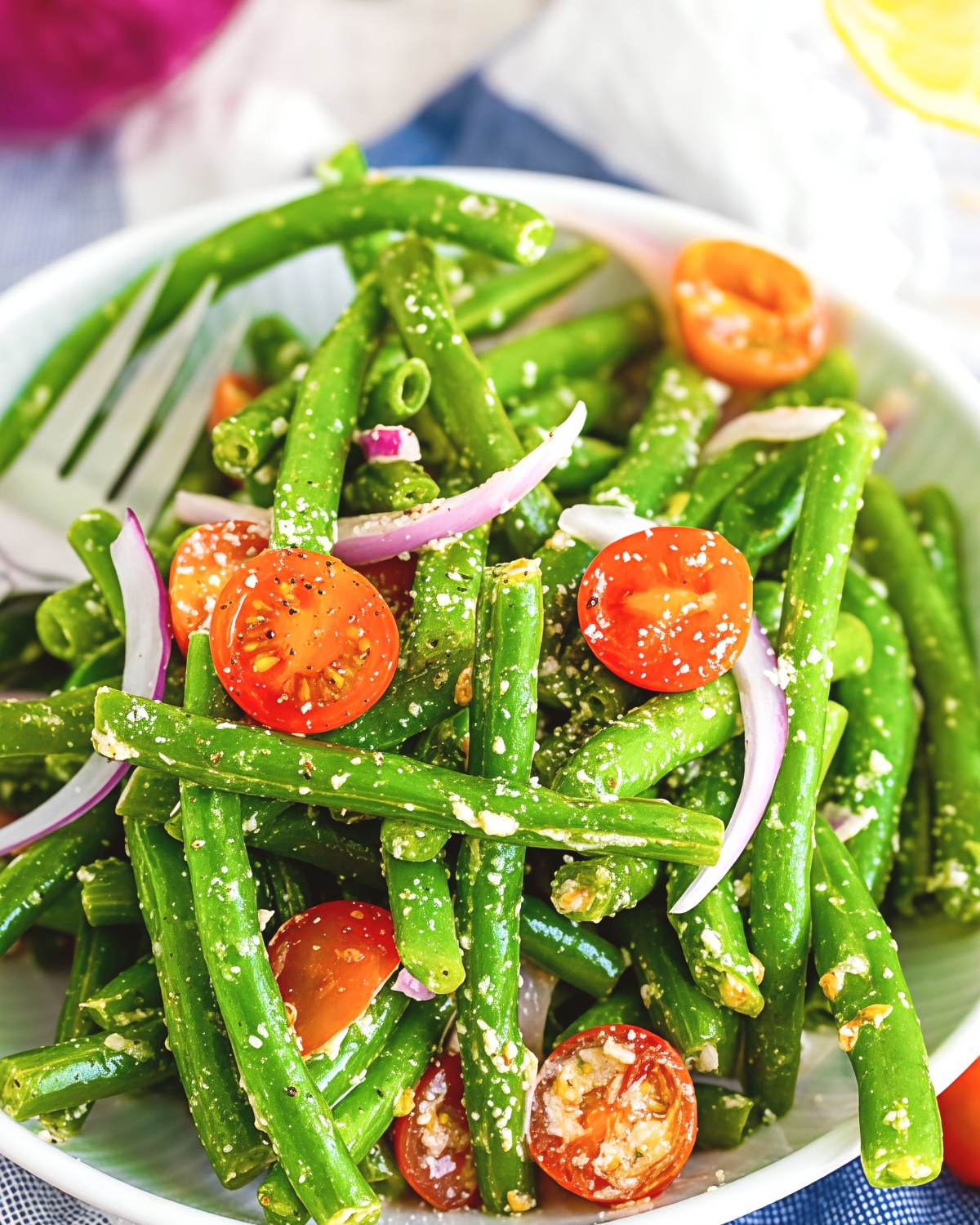 Marinated green bean salad with cherry tomatoes and red onion, served as a cold Thanksgiving side dish