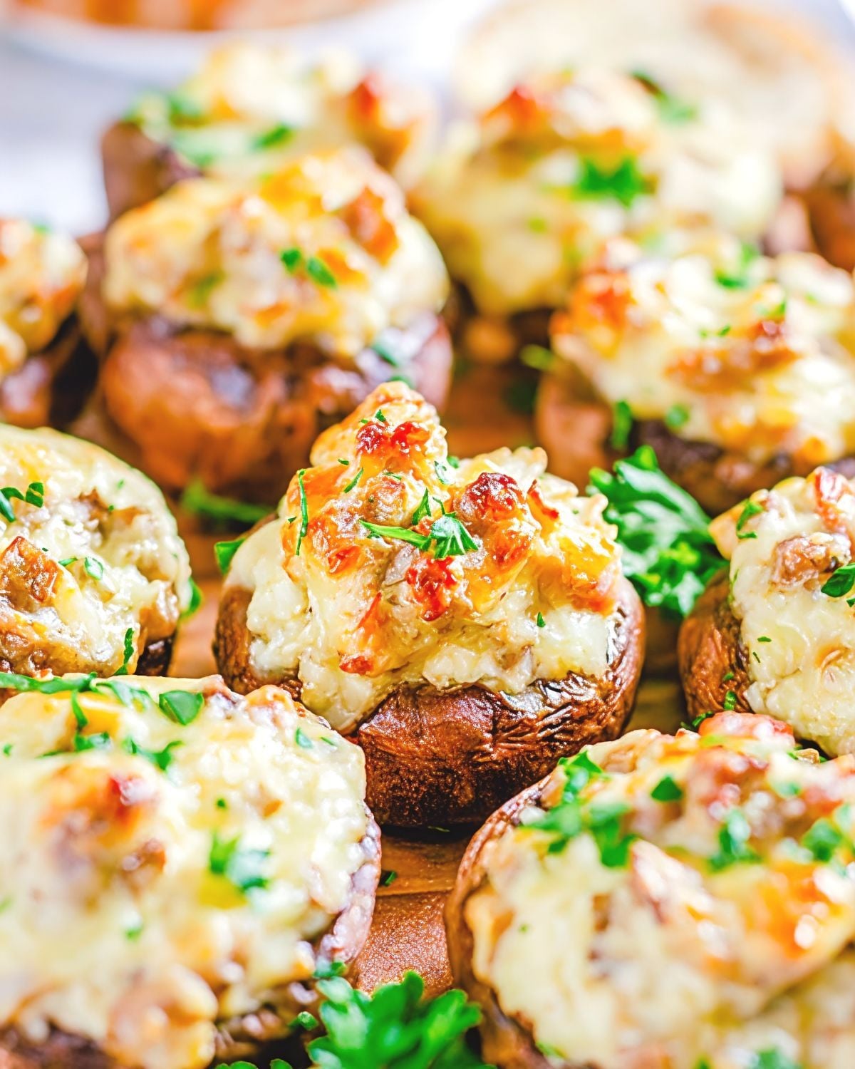 Sausage-stuffed mushrooms loaded with cheese and garnished with fresh parsley as a fall appetizer