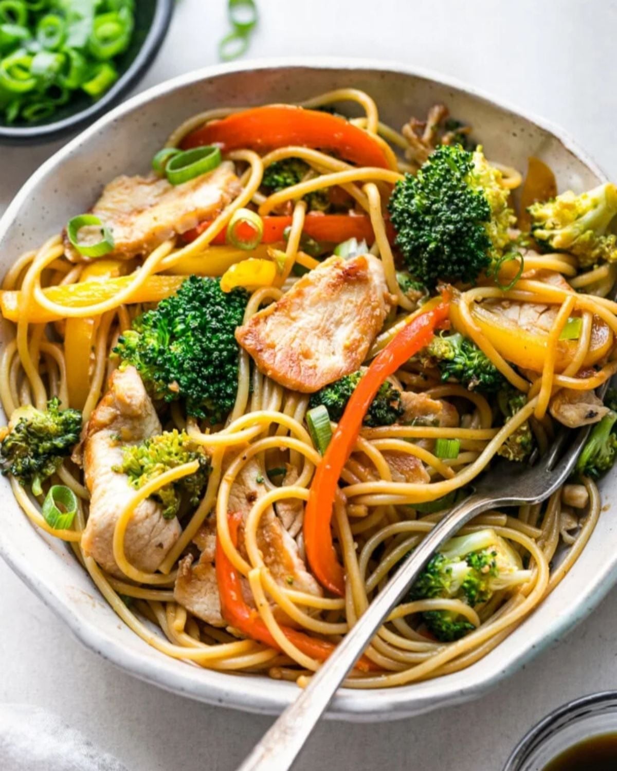 High protein chicken lo mein stir fry with broccoli and bell peppers in a bowl