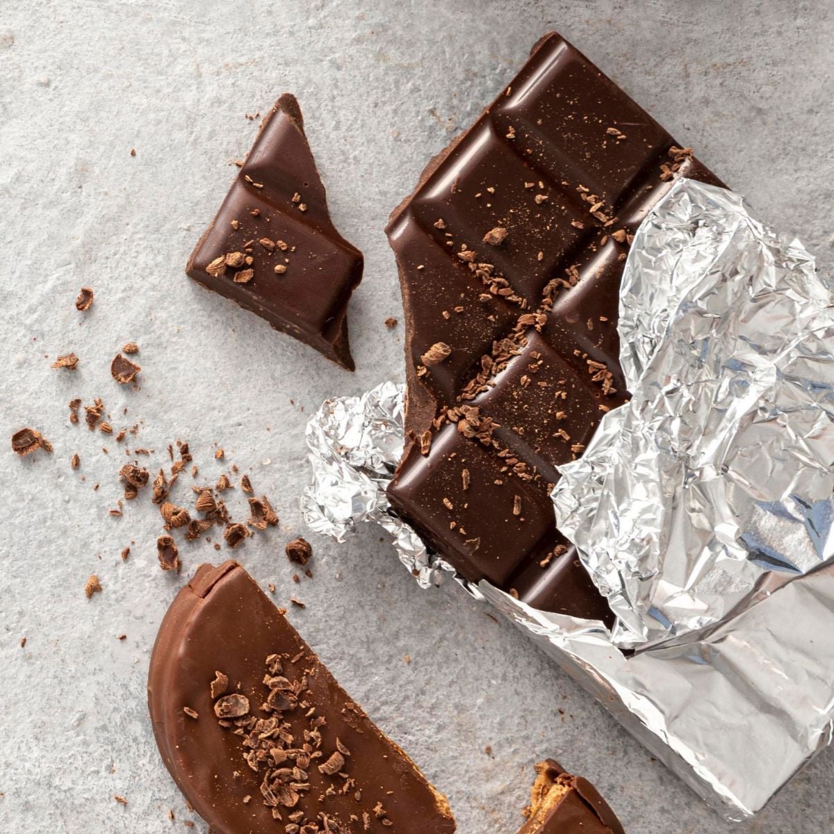 Hershey bar on the counter with a broken block and the rest wrapped in tin foil