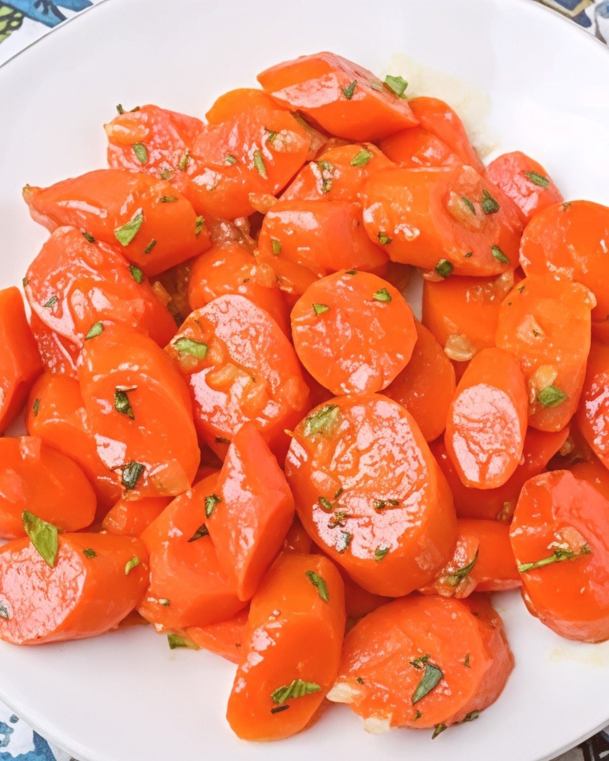Tender tender maple glazed carrots garnished with fresh thyme leaves served in a skillet, perfect for Thanksgiving side dishes for a crowd.