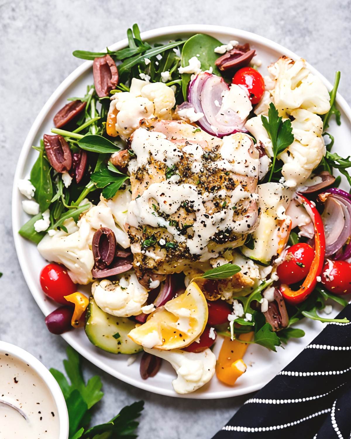 Mediterranean chicken with roasted vegetables, olives, and feta cheese on a plate