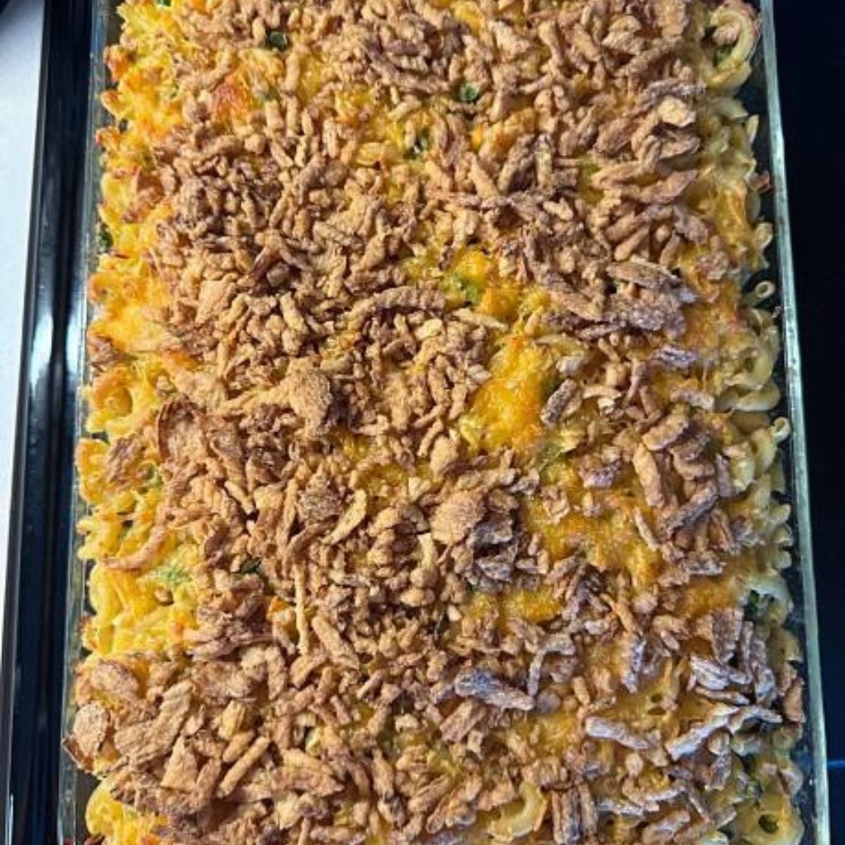 A slightly uneven tuna noodle casserole, with crushed potato chips browned across the top.