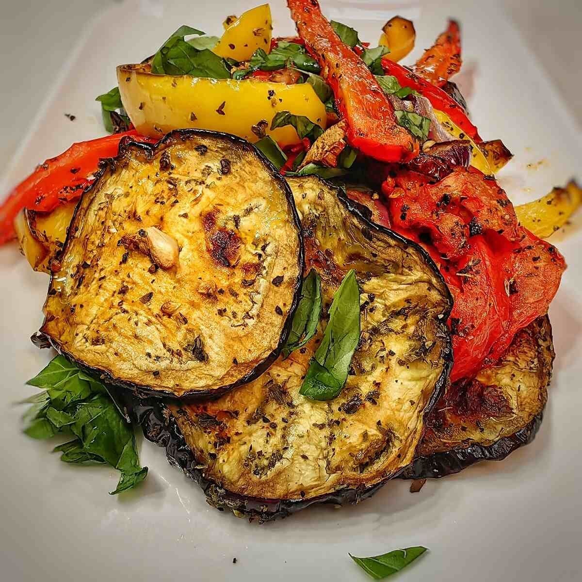 Roasted air fryer vegetables including sliced eggplant, bell peppers, and fresh herbs, served as one of the best gluten-free Thanksgiving side dishes.