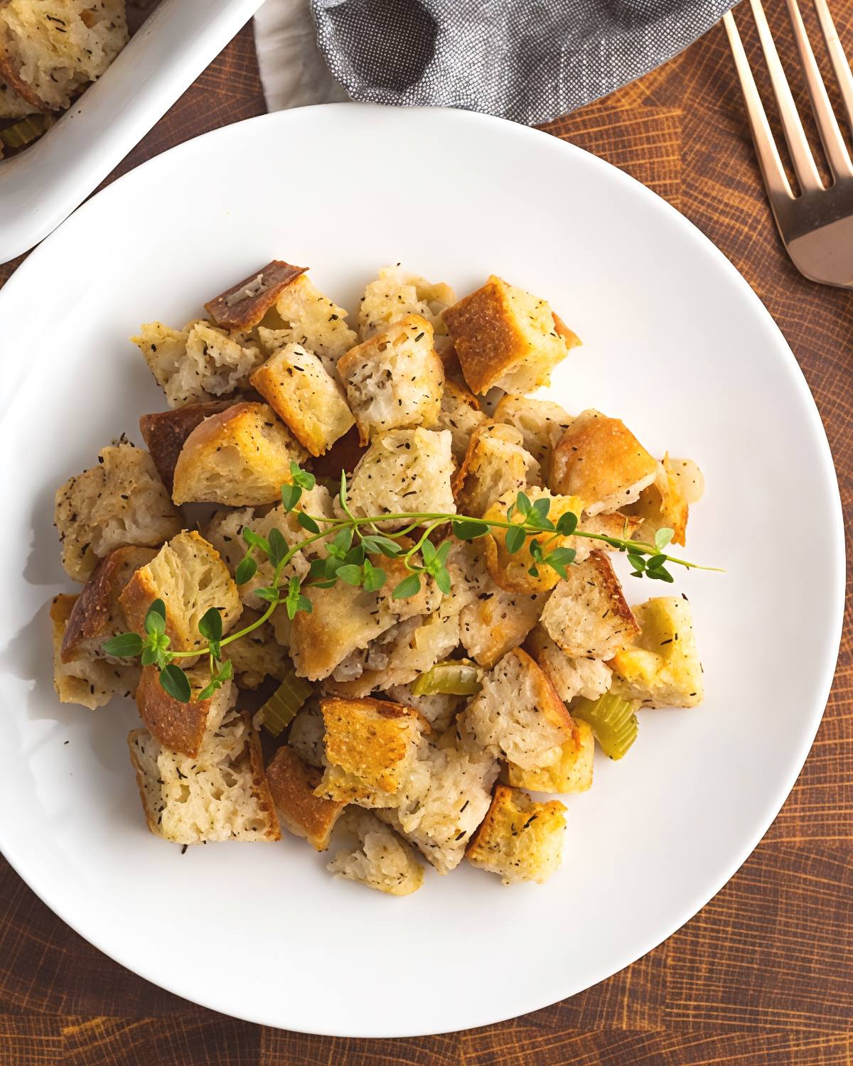 Best vegan stuffing made with crusty bread cubes, celery, and savory herbs on a white plate, perfect for a Thanksgiving side dish.