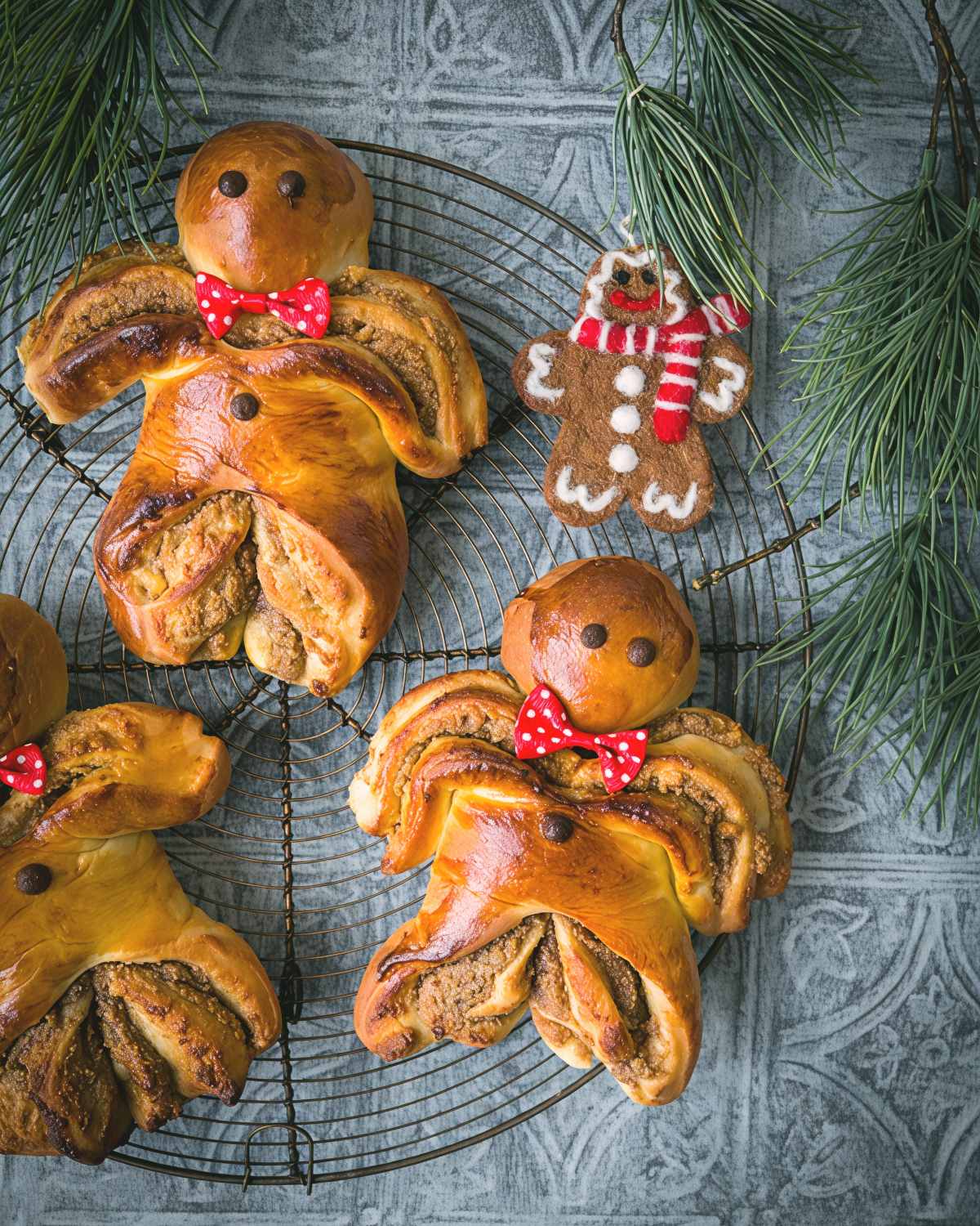 Traditional Luxembourg Boxemännchen brioche pastries shaped like little men and decorated with bow ties arranged on a cooling rack as a European Christmas dessert.