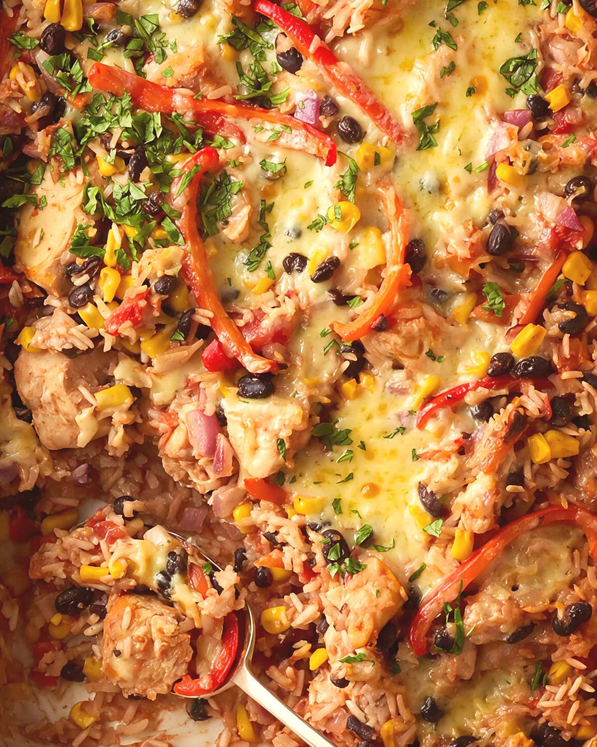 Healthy chicken burrito rice dump-and-bake casserole with black beans, corn, bell peppers, and melted cheese.