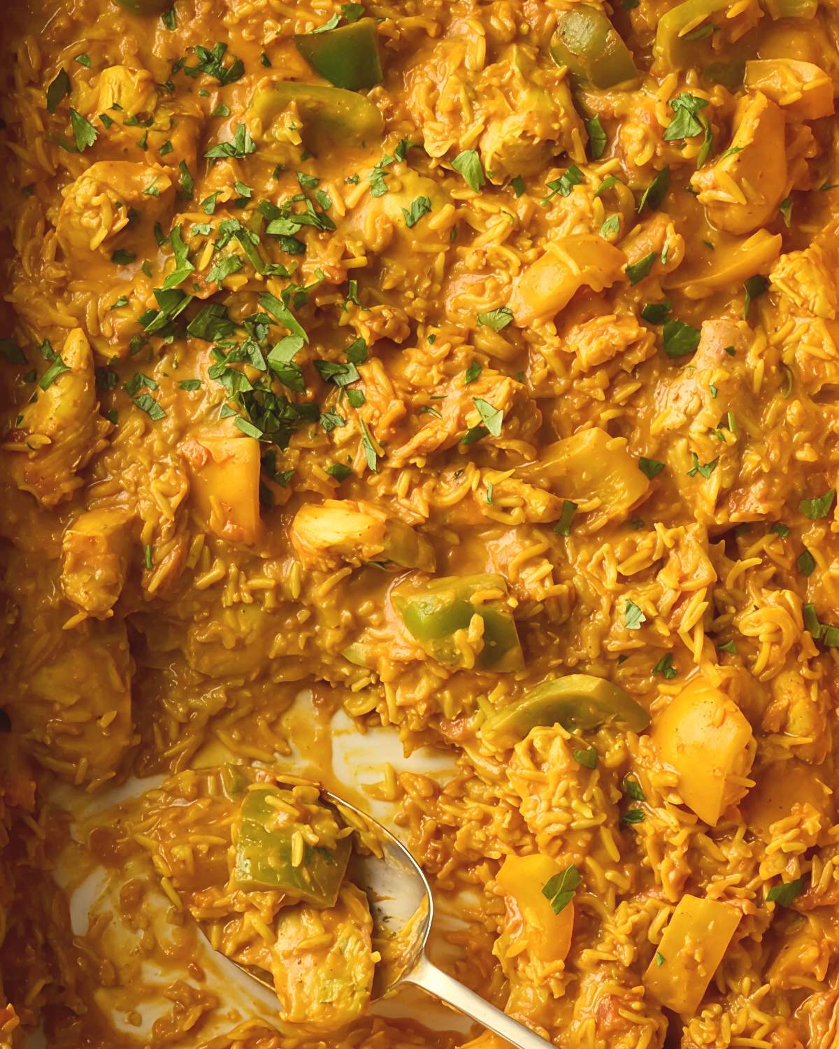 Healthy chicken curry and rice dump-and-bake casserole with bell peppers and fresh herbs.