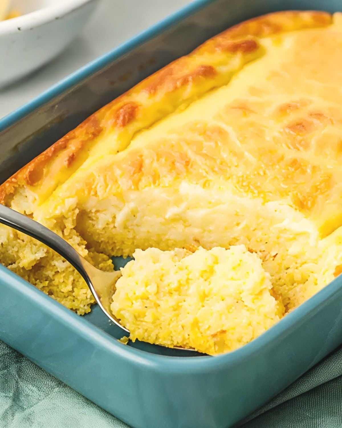 Classic Southern spoon bread baked in a blue baking dish with a soft, moist texture, perfect for Southern Thanksgiving side dishes.