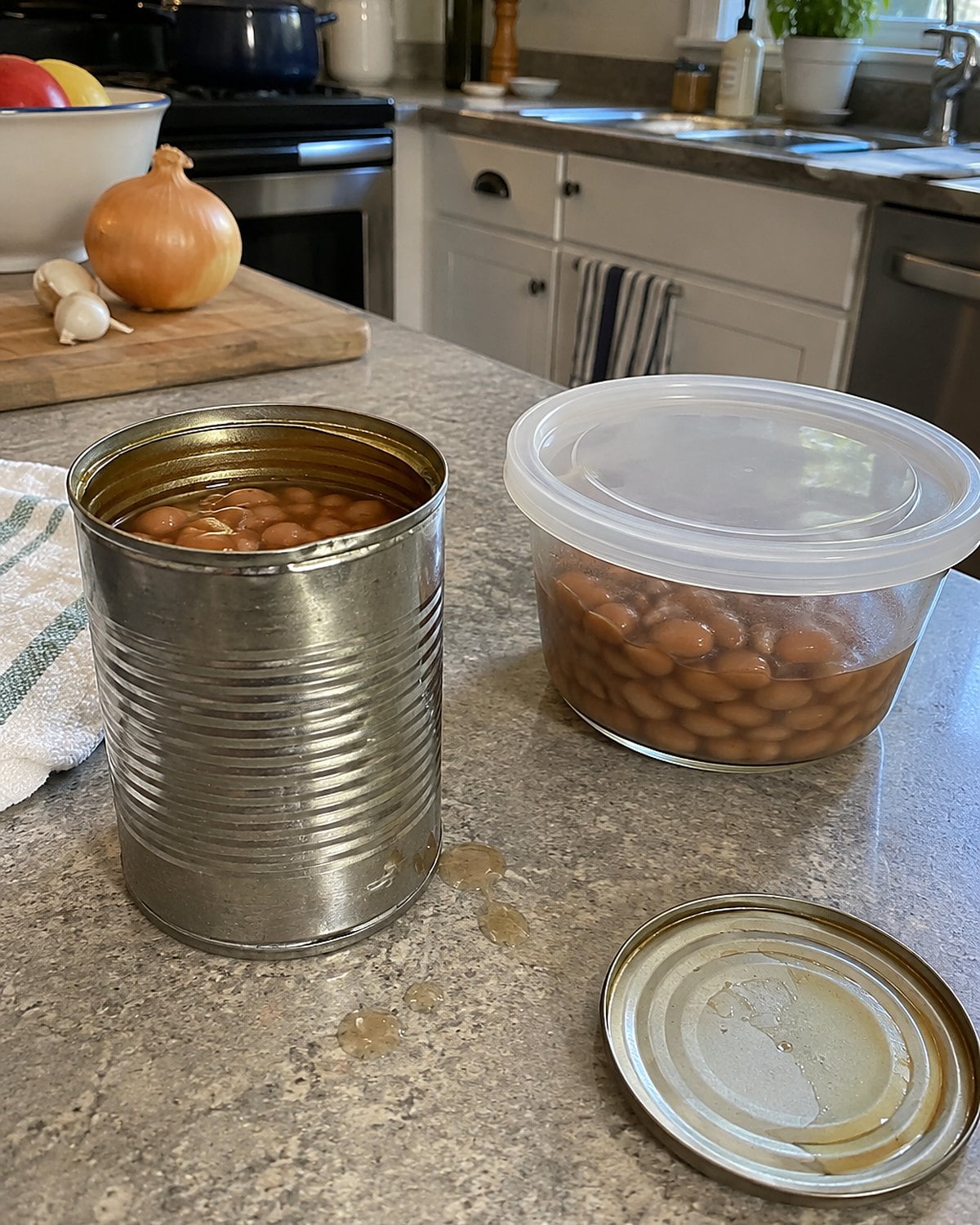 An open can of beans sits beside a covered container holding the unused beans.