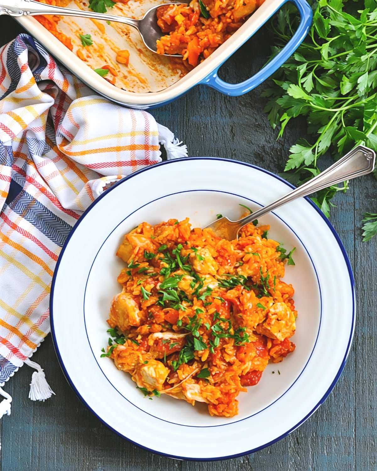 Dump and bake Italian chicken and rice casserole served in a white bowl with fresh parsley.