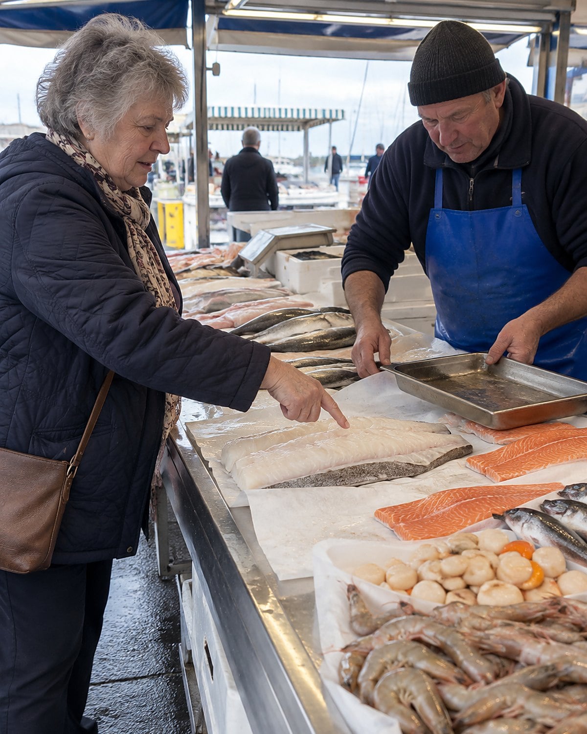 A fish fillet rests on paper at a market stall while a customer points toward its thick end.