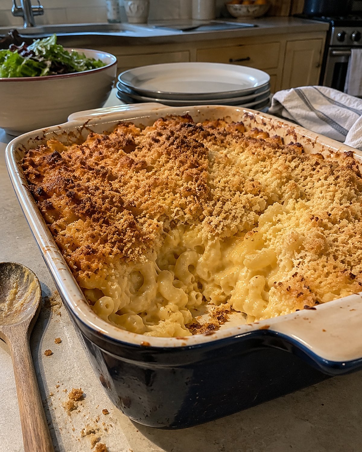 Buttered crumbs scattered across macaroni in an old ceramic casserole dish.