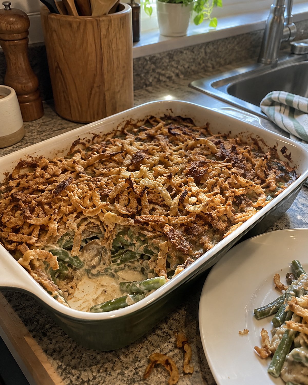 A green bean casserole on a counter, with fried onions scattered across its browned surface.