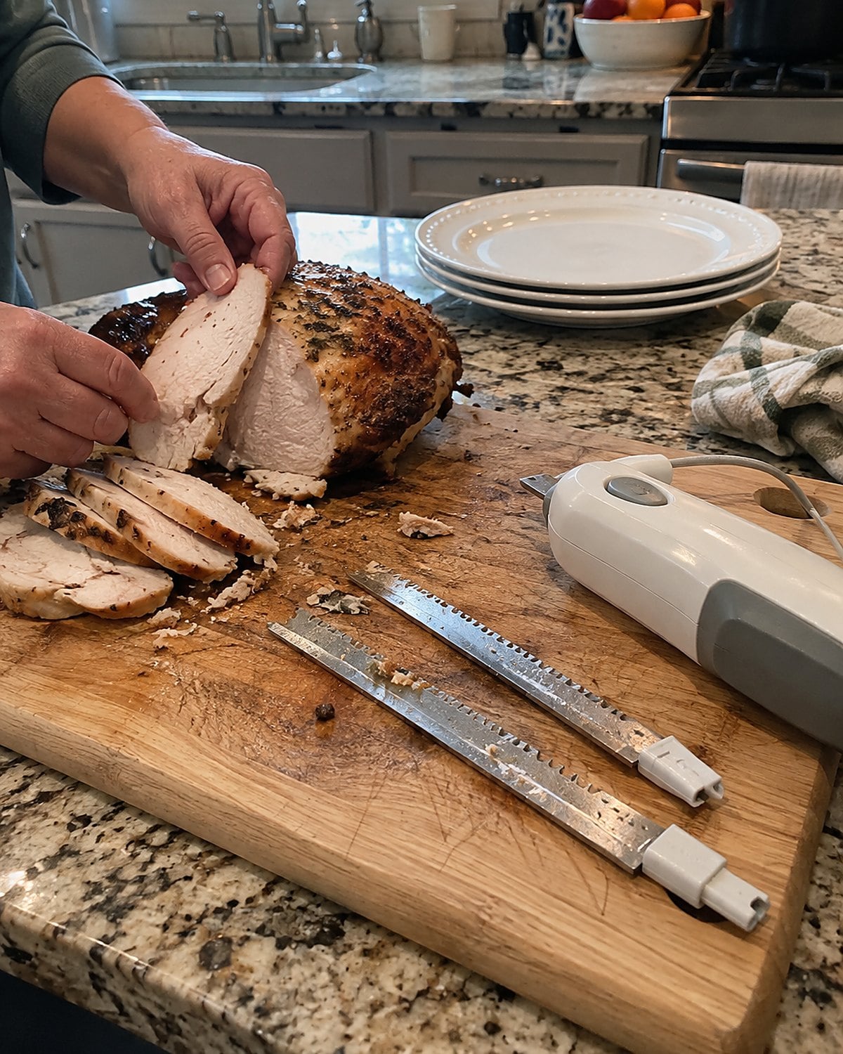An unplugged electric knife with its blades laid separately on a cutting board.