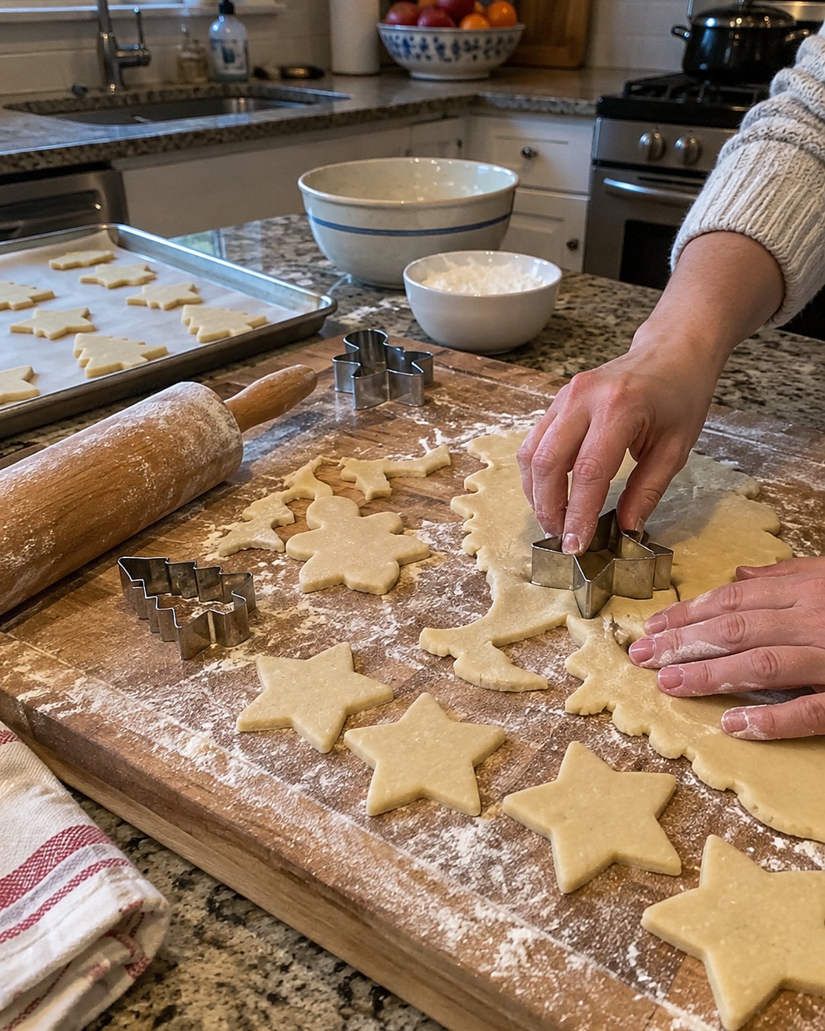 Thin sugar cookie cutouts and scraps cover a floured rolling board beside a star cutter.