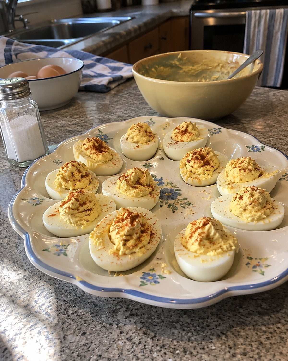 Deviled egg halves sitting unevenly in the hollows of an old serving plate.