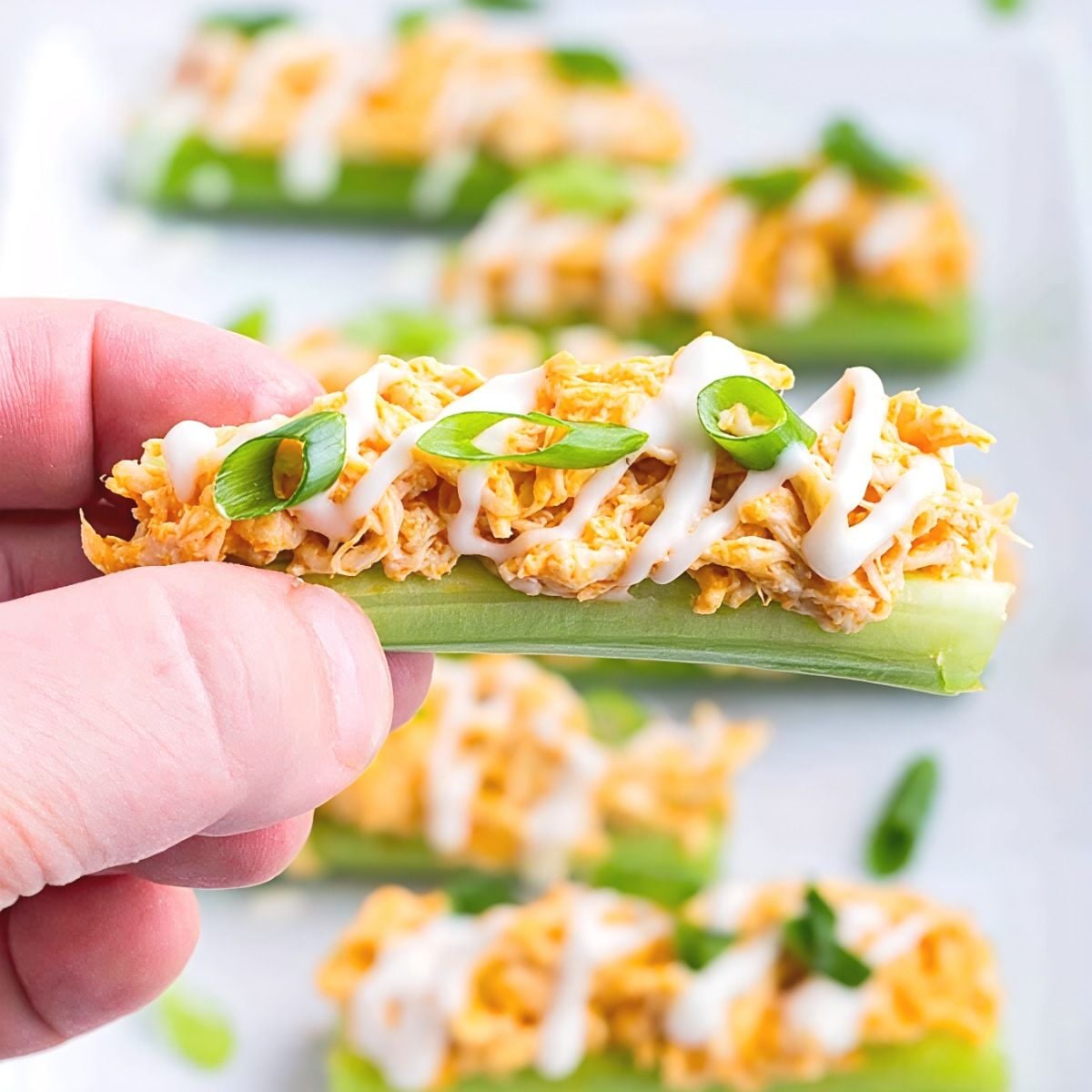 Crisp celery sticks loaded with buffalo chicken dip, drizzled with ranch, and topped with chopped green onions, ideal for healthy gluten free thanksgiving appetizers.