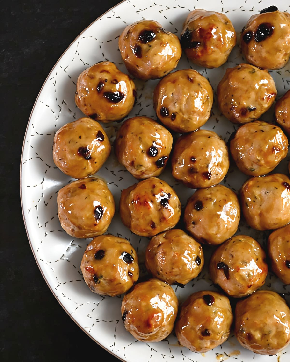 Juicy cranberry turkey meatballs coated in a glossy maple-mustard glaze arranged on a patterned serving platter, ideal for delicious gluten free thanksgiving appetizers.