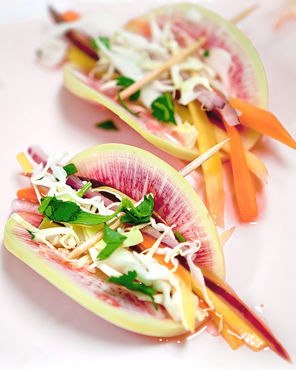 Vibrant watermelon radish mini tacos stuffed with fresh cabbage slaw, julienned carrots, and herbs, held with toothpicks for refreshing gluten free thanksgiving appetizers.