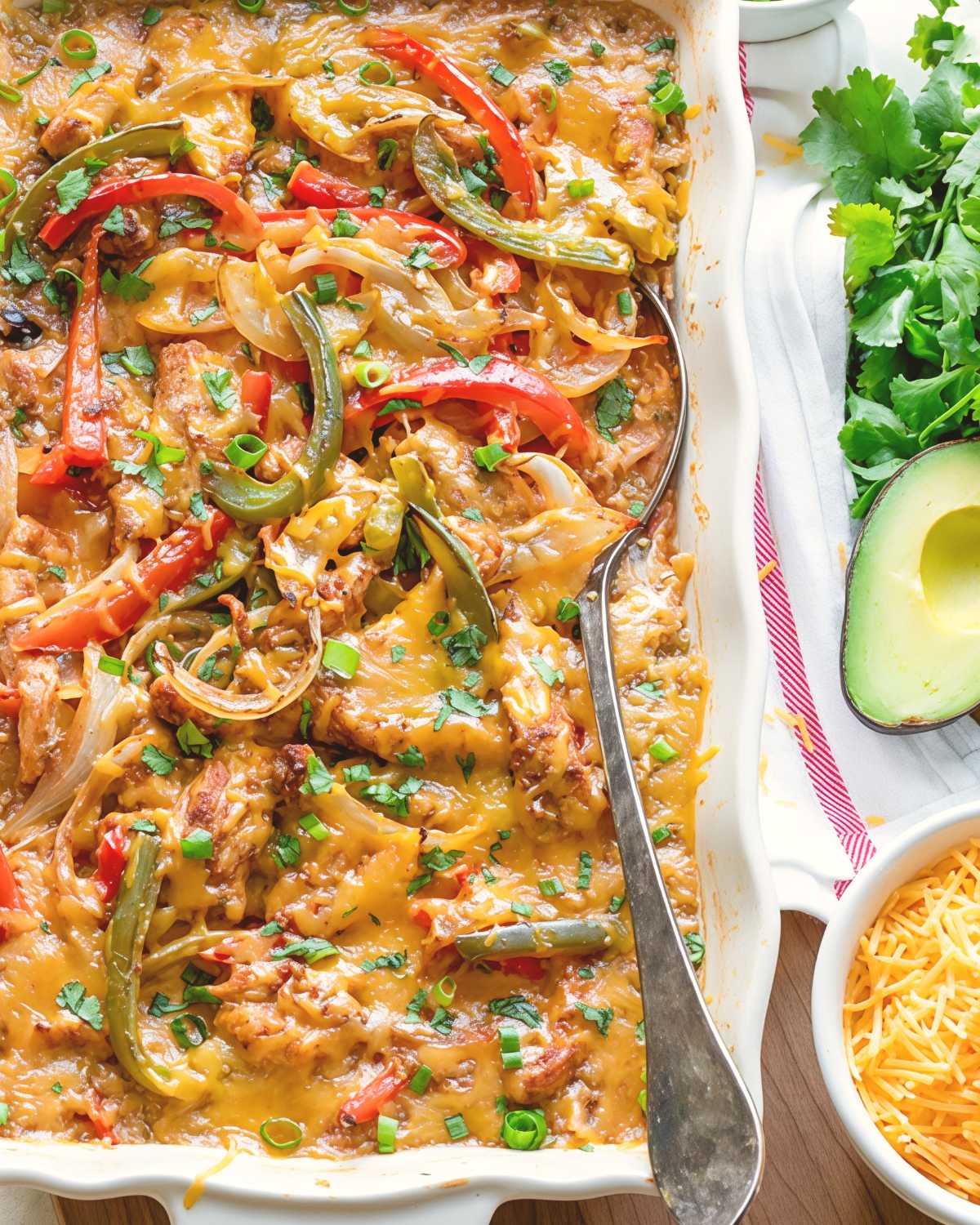 Healthy Mexican chicken fajita dump and bake casserole topped with melted cheese, bell peppers, and onions.