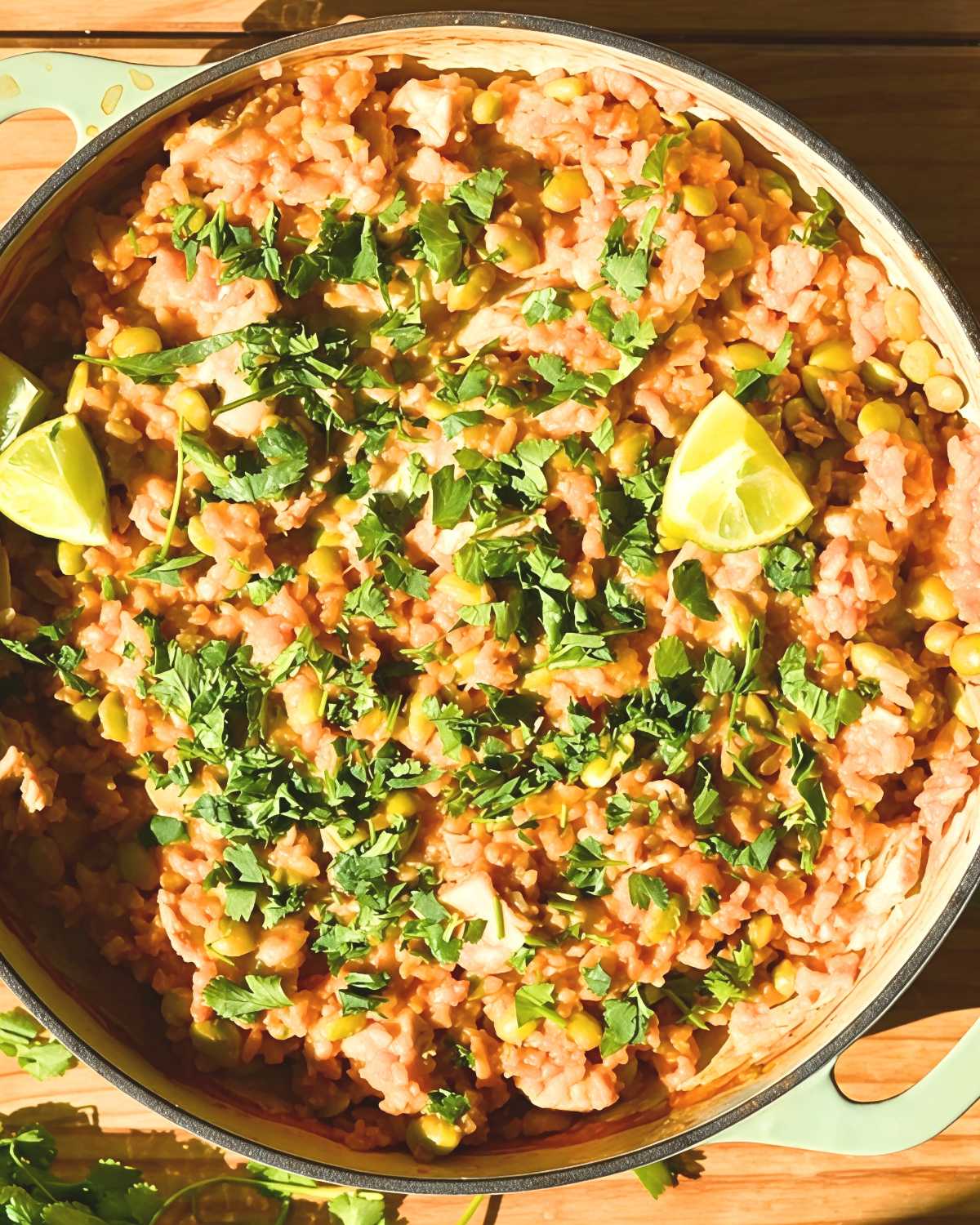 High-protein curry chicken and rice dump-and-bake casserole garnished with fresh herbs and lime wedges.