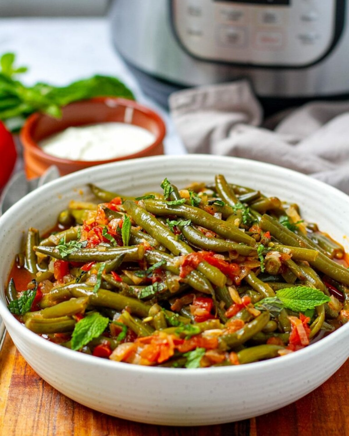 A bowl of Turkish-style Instant Pot braised green beans cooked with tomatoes and herbs, served as one of the best gluten-free Thanksgiving side dishes.