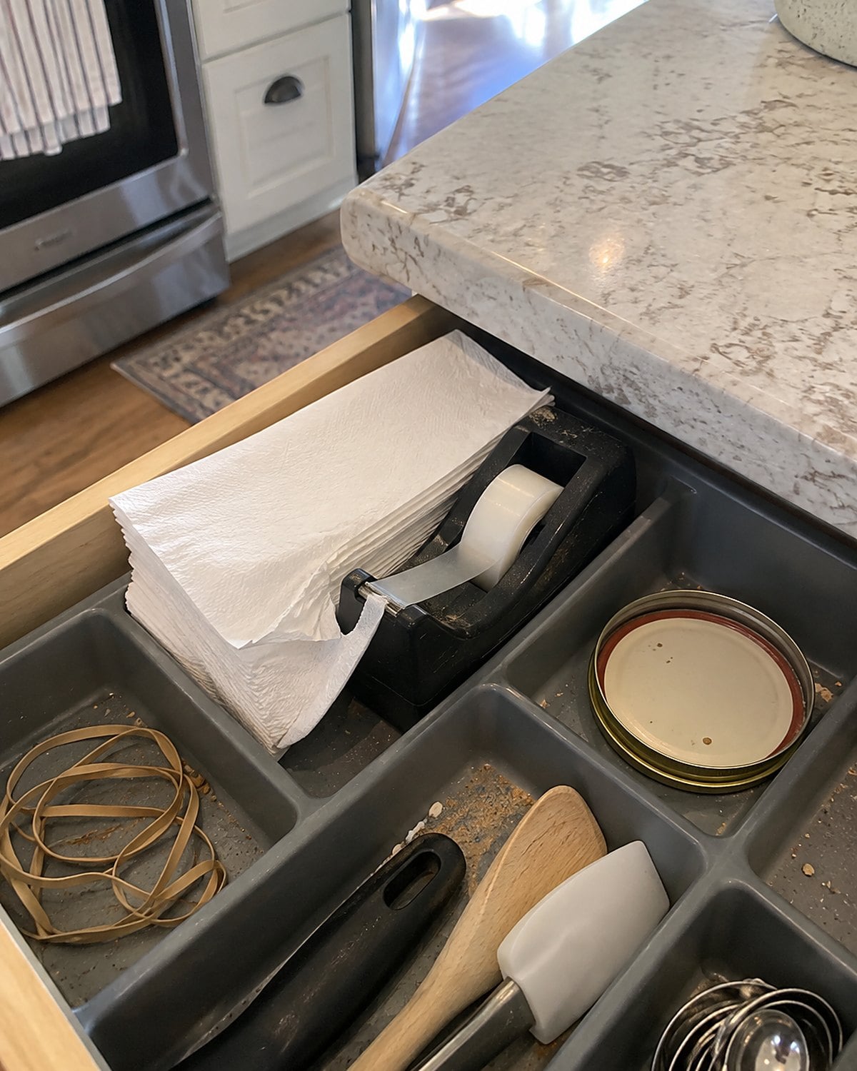 A stack of takeout napkins pulled from behind a tape dispenser in a kitchen drawer.