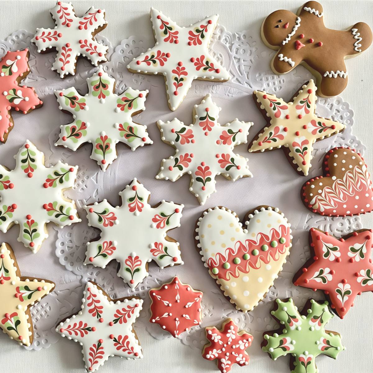 Intricately decorated Latvian Piparkūkas gingerbread cookies shaped into stars, snowflakes, and hearts with festive royal icing, displayed as a traditional European Christmas dessert.