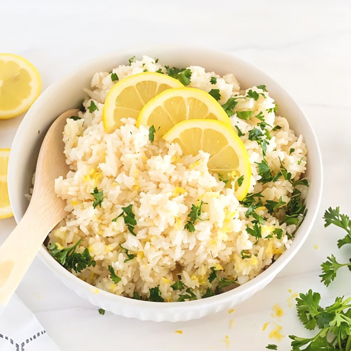 A bowl of fluffy Instant Pot lemon rice garnished with chopped herbs and fresh lemon slices, perfect for leftover turkey recipes.