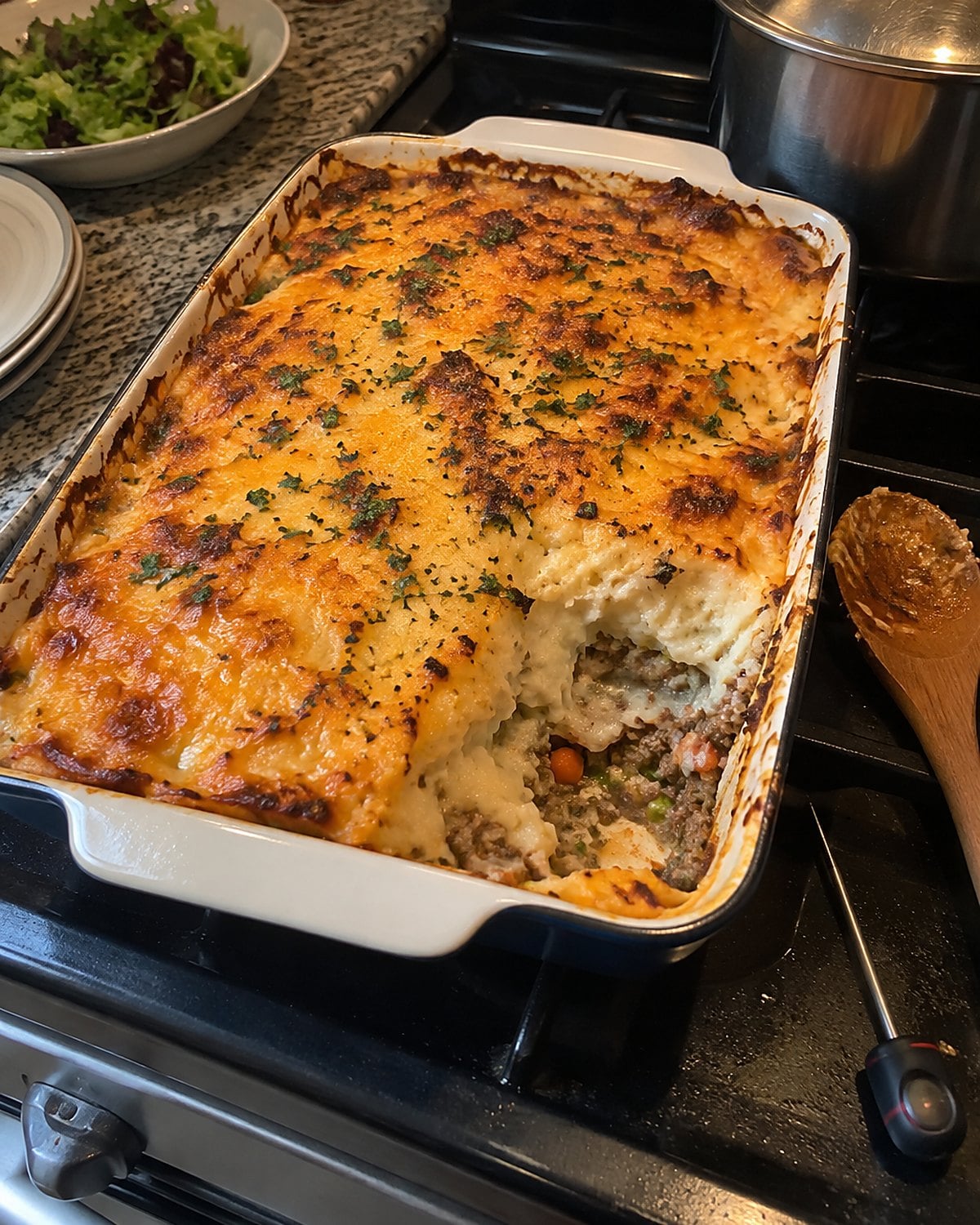 An uneven casserole in a baking dish sits on the stove beside a food thermometer.