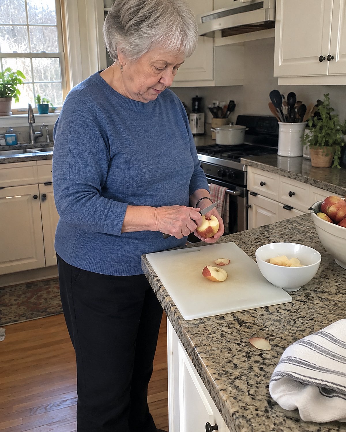 Older hands trim a bruised apple over a cutting board, with the sound pieces in a nearby bowl.