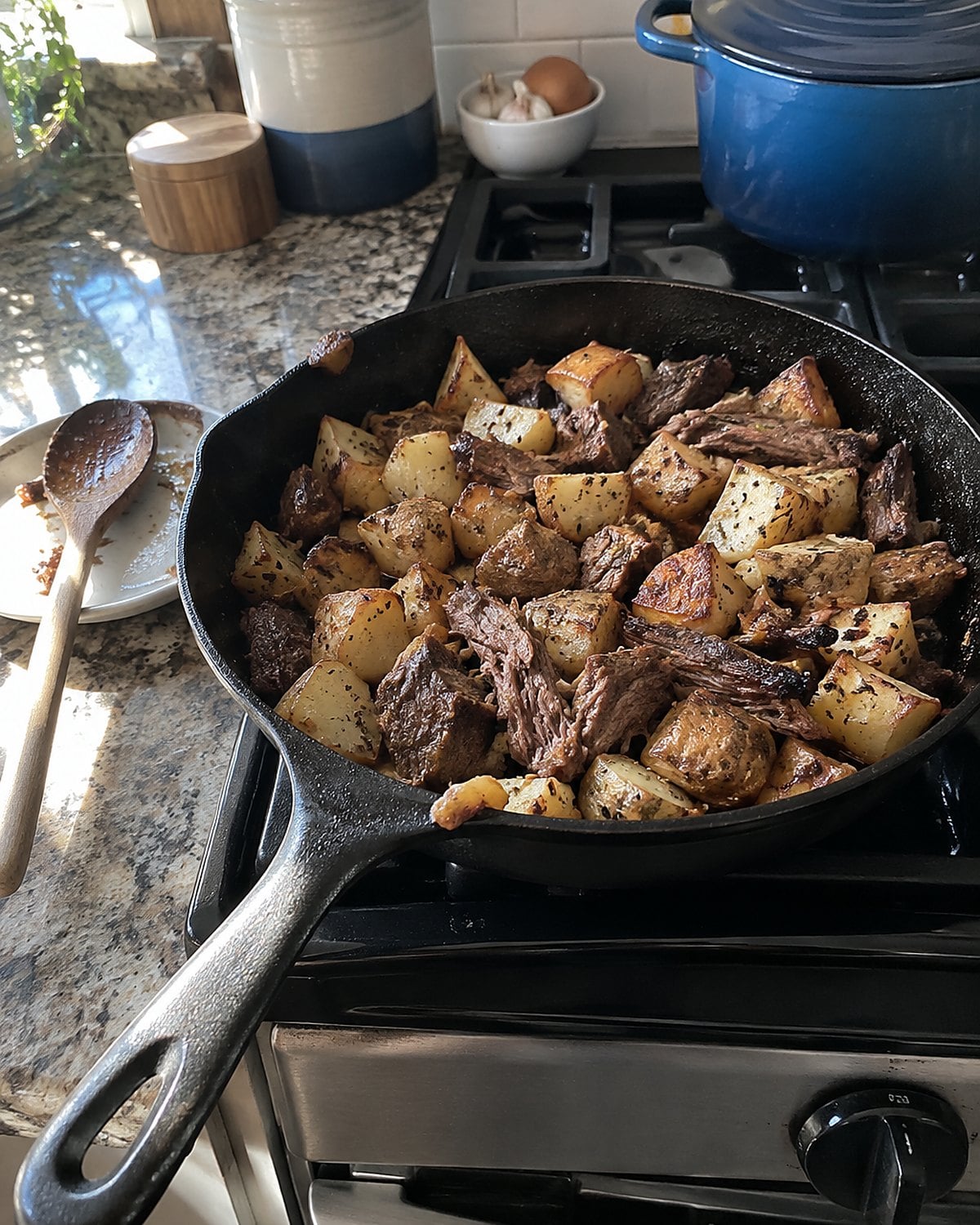 Crisp potatoes and chopped roast fill a cast-iron skillet on the stove.
