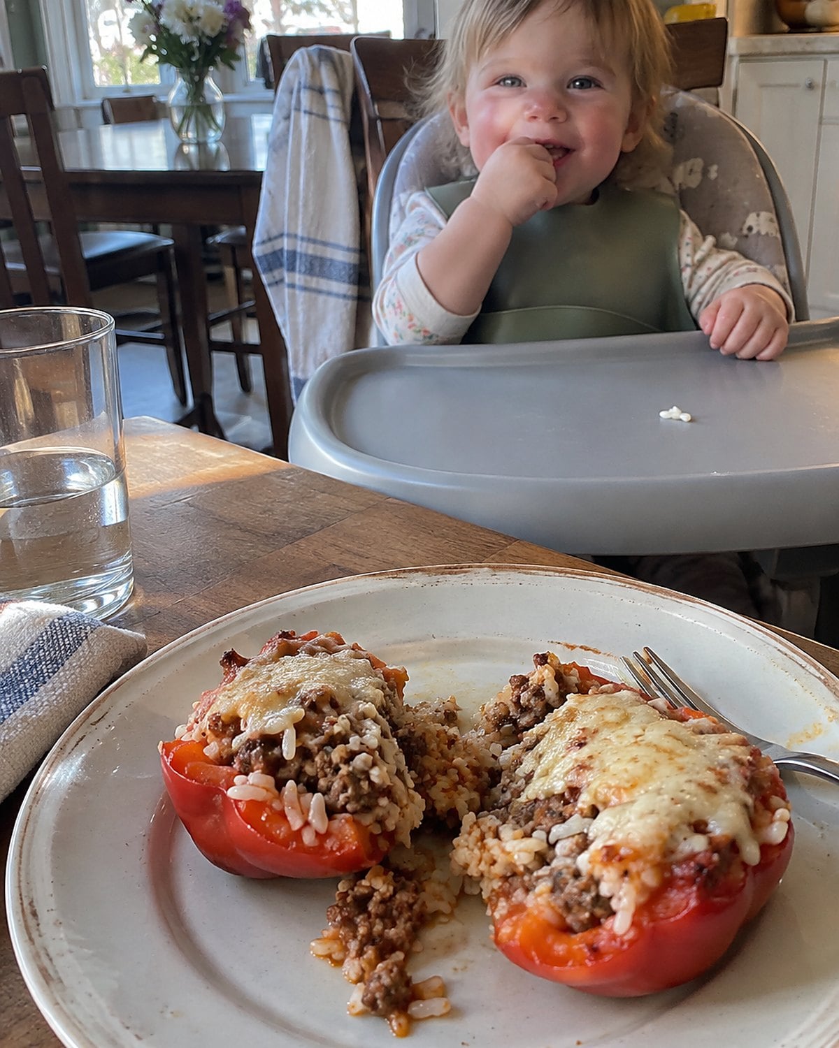 A cut stuffed pepper rests beside a grandchild's high chair tray.