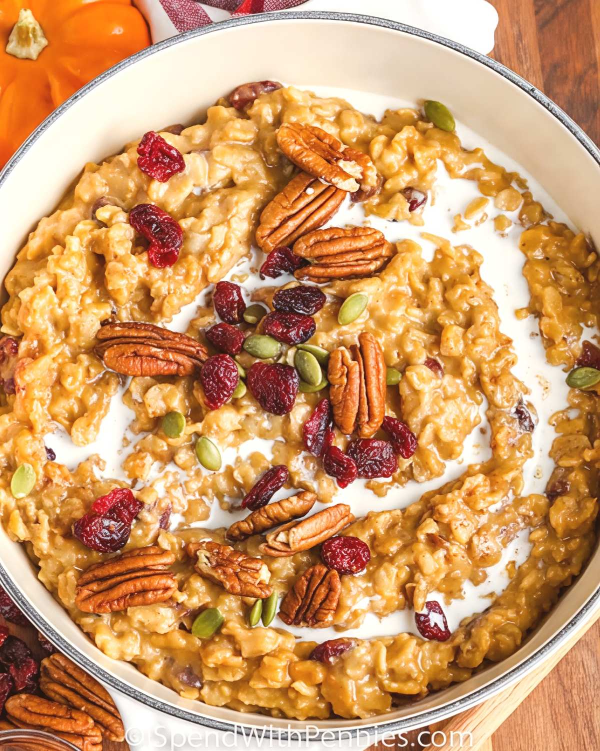 Creamy pumpkin maple oatmeal topped with pecans, cranberries, pumpkin seeds, and a swirl of milk as Thanksgiving breakfast ideas.