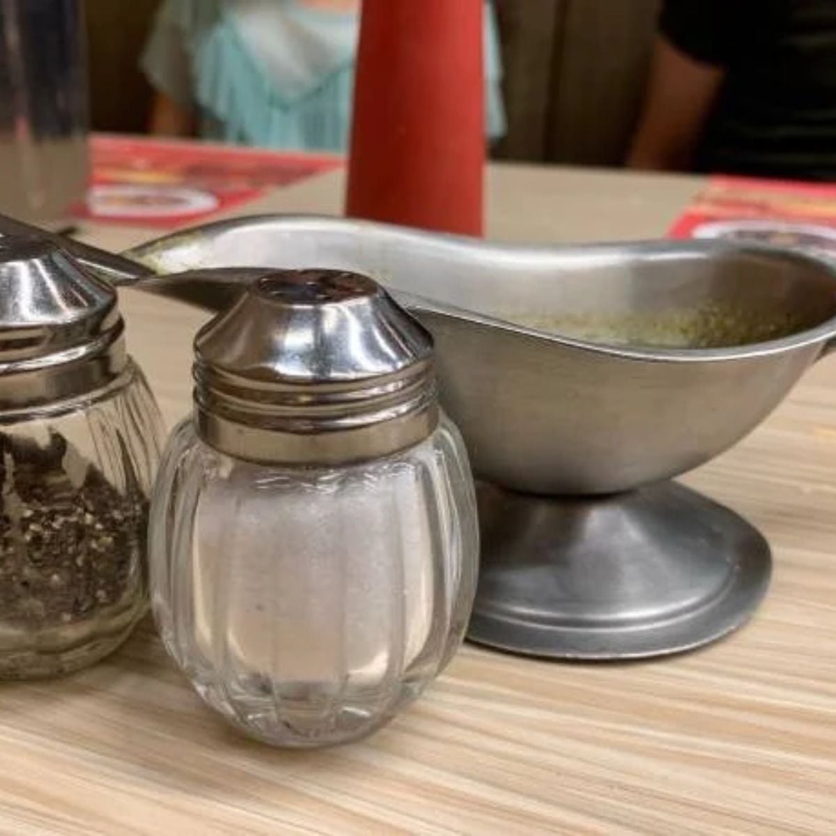 pepper and salt shaker beside the gravy boat on the kitchen counter