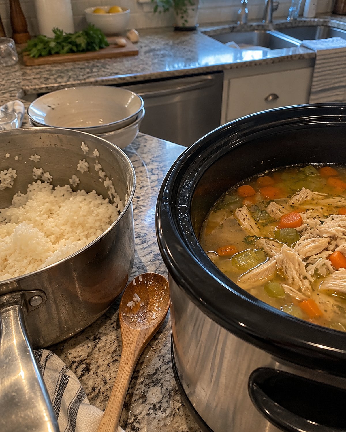 A small saucepan of cooked rice beside a slow cooker of chicken soup.
