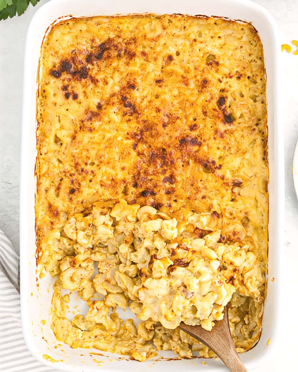 Southern baked macaroni and cheese in a white casserole dish with a golden-brown baked cheese crust, perfect for Thanksgiving side dishes.