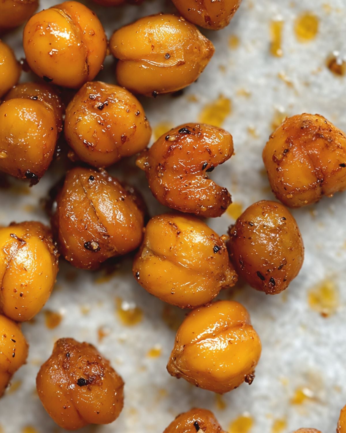 Golden-brown spiced crispy chickpeas seasoned with spices and olive oil scattered on parchment paper for a healthy, light Thanksgiving appetizer.