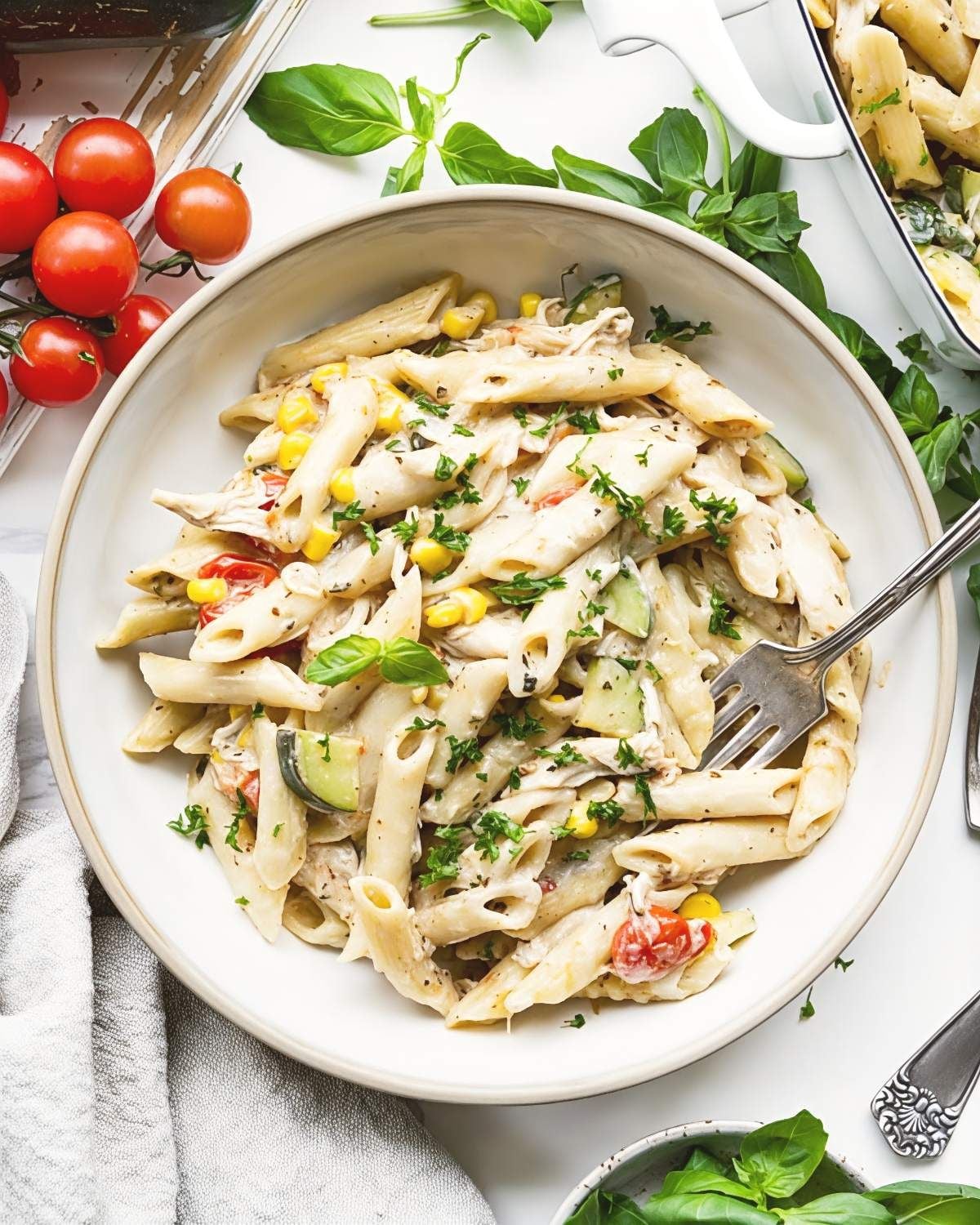Summer pasta dump and bake casserole with zucchini, corn, and cherry tomatoes in a bowl