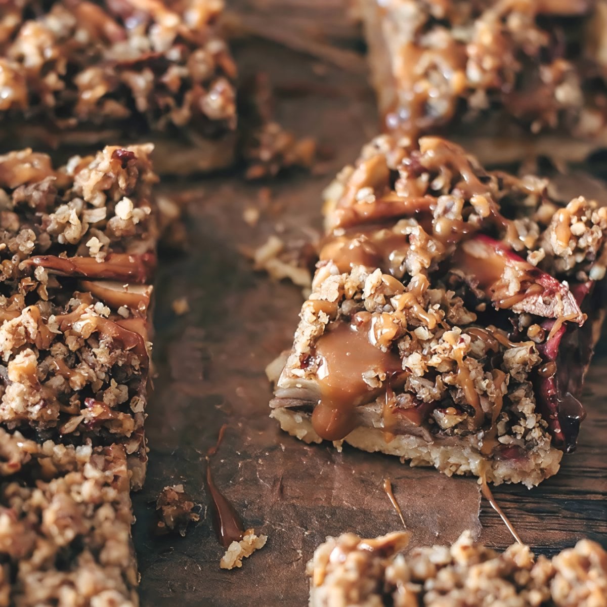 Freshly baked apple pecan bars drizzled with warm caramel glaze and finished with a crunchy pecan crumble, served as easy Thanksgiving potluck desserts.