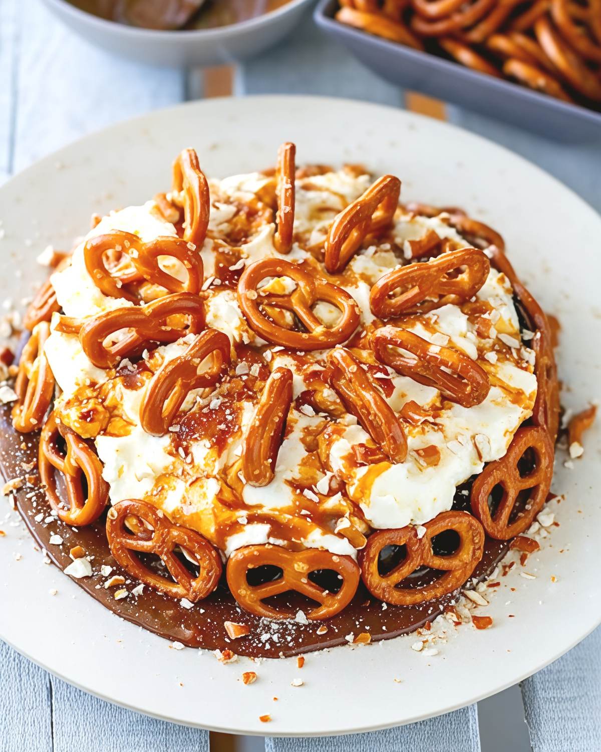 A rich Instant Pot chocolate caramel pretzel cake topped with fluffy whipped cream, salted caramel drizzle, and crunchy pretzels, ideal for Thanksgiving potluck desserts.