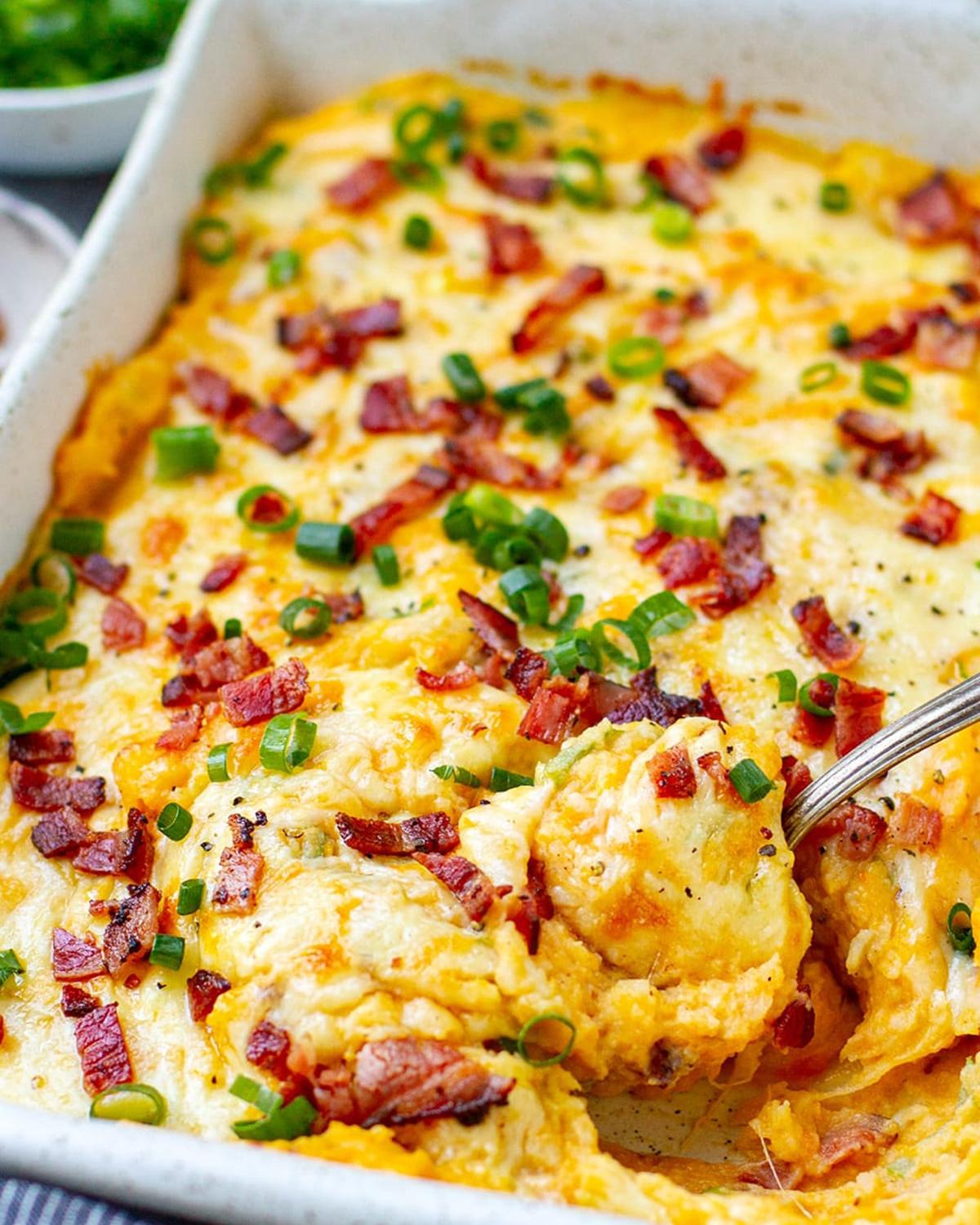 Creamy Instant Pot loaded mashed potatoes casserole topped with melted cheddar cheese, crispy bacon bits, and sliced green onions, perfect as Thanksgiving side dishes for a crowd.